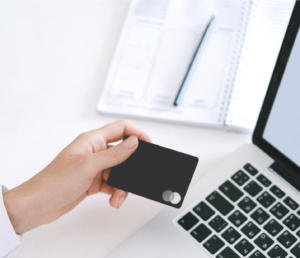 hand holding a credit card over a computer